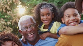 Portrait of multi-generation African American family with parents giving children piggyback ride in garden at home - shot in slow motion
 - Powered by Shutterstock - Get 15% off with code: PIKWIZARD15