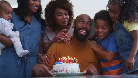 Multi-generation African American family celebrating fathers birthday at home together - shot in slow motion
