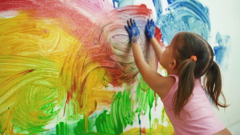 Little Girl Child Preschooler Draws Hands Paints On White Wall.