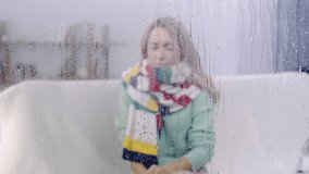 ill woman sneezing behind glass with drops