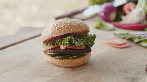 Fresh vegan burger on wooden table.