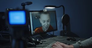 Medium shot of a programmer talking with a boy during a video call