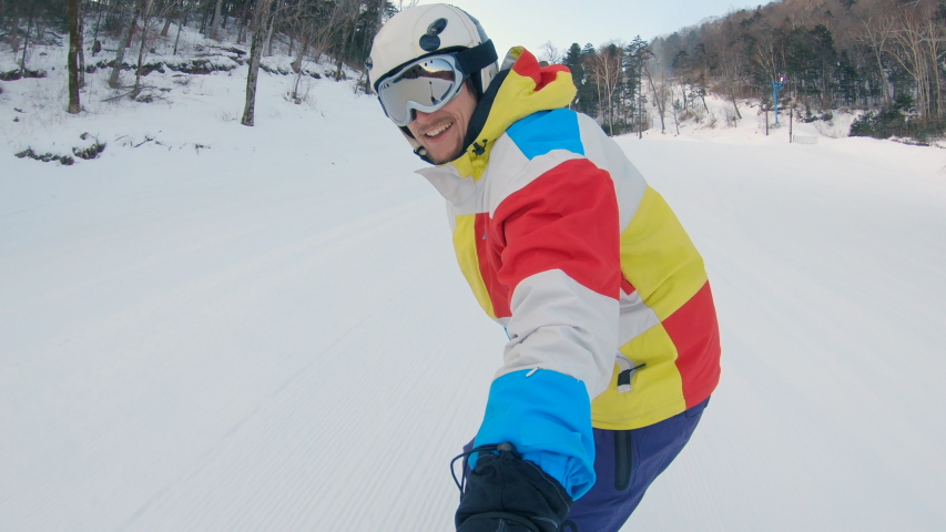A man rides on a snowboard down the ski slope. Winter recreations concept