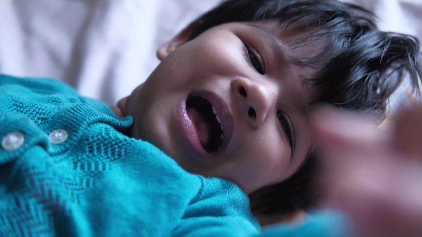 Close up of baby girl on bed crying 