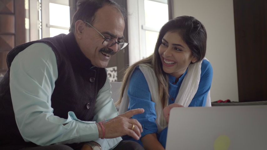Smiling Daughter teaching her father how to make payment using online banking on a laptop. A beautiful and traditional young woman showing an elderly man how to shop buy things online.  Royalty-Free Stock Footage #1047184993