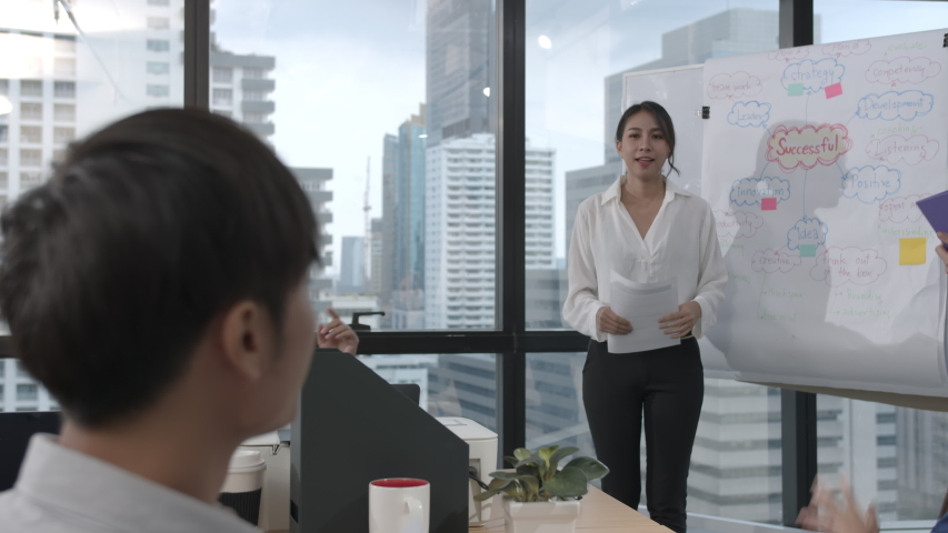 Young asian business woman presenting data idea marketing on board in office. Asia woman show mind mapping and ideas to business partner or colleagues group enjoy teamwork in small office Royalty-Free Stock Footage #1047193510