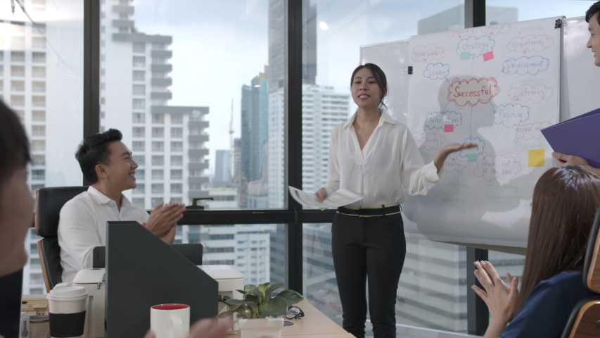 Young asian business woman presenting data idea marketing on board in office. Asia woman show mind mapping and ideas to business partner or colleagues group enjoy teamwork in small office | Shutterstock HD Video #1047193510