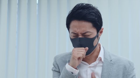 Coughing asian businessman. Surgical mask.