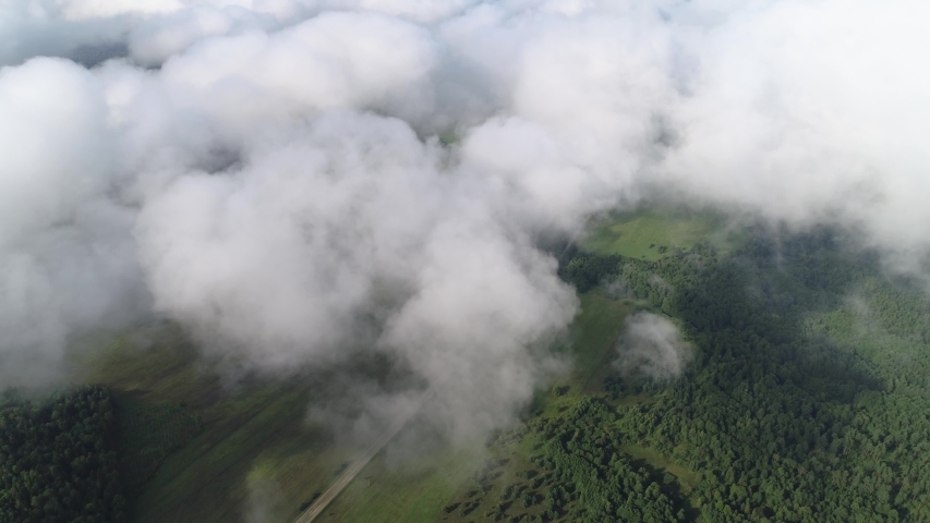 High-speed and smooth flight through the cloud. Rapid descent and departure from the cloud. Below you can see the rural landscape, rivers, fields, villages, forests.