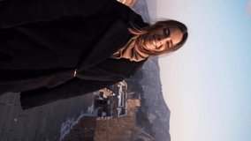 Happy woman walk at Great Wall of China, come down from watch tower at Badaling section at sunset in winter. Vertical video
