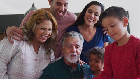 Multi-Generation Hispanic Family Celebrating Grandfathers Birthday At Home Together