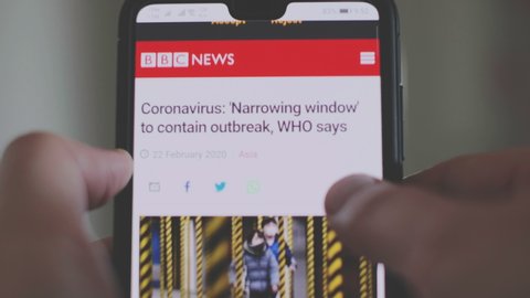 Hand scrolls and read the Coronavirus covid-19 news articles on a smartphone in Bologna, Italy, 22 Feb 2020