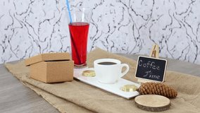 Coffee cup with juice glass with candy and wooden board on spinning wooden table background. FHD.