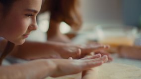 Closeup girl hands rolling dough on kitchen table in slow motion. Young girl helping mother on kitchen. Mother and daughter hands preparing dough at home together. Child hands cooking with rolling pin - Powered by Shutterstock - Get 15% off with code: PIKWIZARD15