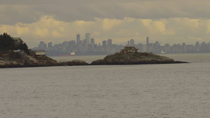 Island houses near Horseshoe Bay, BC, Canada, with the Vancouver skyline in the background. In slow motion. 4k.
