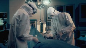 Coronavirus covid-19 Infected Patient on bed in Quarantine Room at Hospital with Disease Control Doctors Wearing Hazmat Sterile Suits trying to Make Coronavirus Disease Treatment - Powered by Shutterstock - Get 15% off with code: PIKWIZARD15