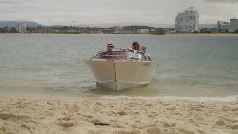 Group of friends getting out of a boat and walking to a picnic on the beach in Australia with soft day lighting. Medium to Wide shot on 4k RED camera.