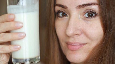 Close up portrait woman drinking a milk drink - milk, kefir, yoghurt