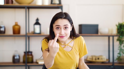 Angry girl showing fuck you and expressing negative emotions at home