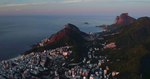 Aerial view of Rio de Janeiro and mountains surrounding the city by the ocean, Brazil. Warm sunrise light