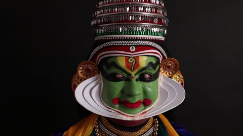 Kathakali dancer smiling and expressing emotions with his eyes.