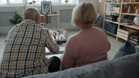 Cheerful elderly people are talking to happy young couple making online video call with laptop at home communicating to family. Computers and internet concept. - Powered by Shutterstock - Get 15% off with code: PIKWIZARD15