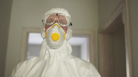 Coronavirus protection, pandemic threat Covid19. Close portrait of a man in a protective insulating suit and mask