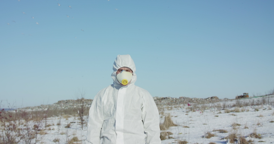 Man wore in white full cover suit raises protest sign save the planet on snowed up lonely territory. Slowly in 4K