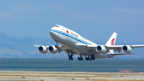 SAN FRANCISCO, CA - 2020: Air China Boeing 747-8 Intercontinental Jet Airliner Taking Off from Runway Departing San Francisco SFO International Airport Flying into a Sunny Blue Sky in California
