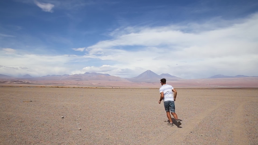 Man is jumping around in desert landscape on a sunny day