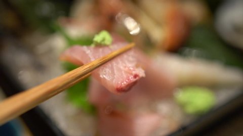 People eating sashimi set in japanese restaurant. Sashimi hamachi and wasabi.
