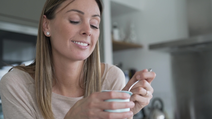 Portrait of woman eating yoghurt | Shutterstock HD Video #1047332677