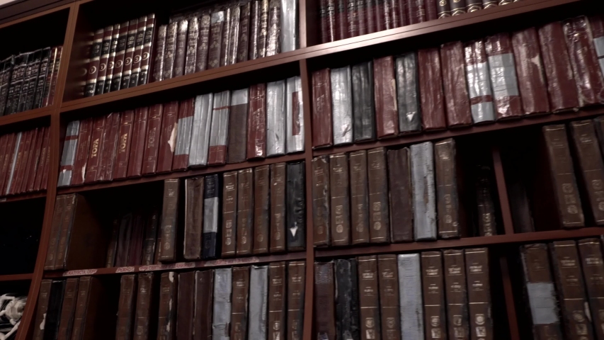 Modern Jewish library in Synagogue. Bookshelves with volumes. Traditional books in Judaic library: Torah, Talmud. Historic building of Jewish community. House of Jewish Spirituality and Divine Law. Royalty-Free Stock Footage #1047345604