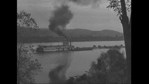 CIRCA 1940s - A steamship pushes a barge.