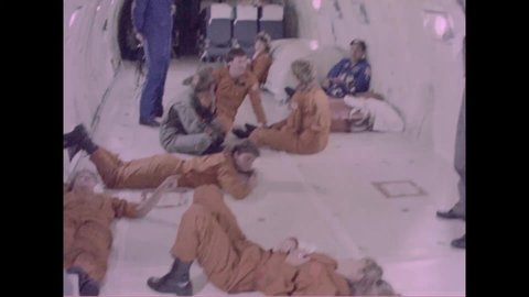 CIRCA 1980s - Gymnasts are shown in zero gravity with astronauts floating aboard a spacecraft.