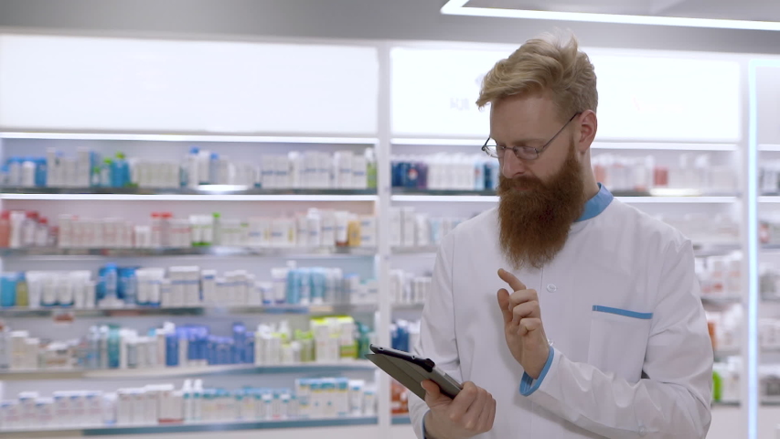 Portrait of pharmacist  uses a tablet pc and checks drug database during inventory  in the hospital pharmacy,  then nods negatively | Shutterstock HD Video #1047361144