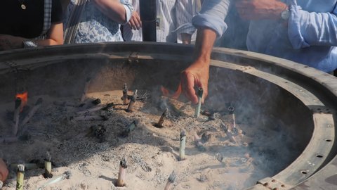 TOKYO, JAPAN - CIRCA 2018: People in the shrine in Ueno Park burning incense sticks as a ritual