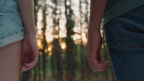 teenage couple holding hands in forest at sunset boyfriend and girlfriend sharing romantic connection in woods happy young lovers Stockvideo