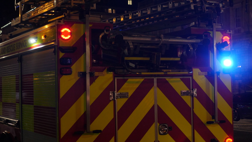 4K: UK Fire Engine at Night with lights flashing and sirens going. Fire Department Truck - Stock Video Clip Footage Royalty-Free Stock Footage #1047379753