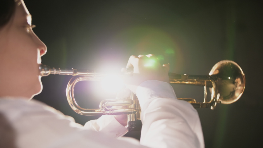 Musician Playing Trumpet. Live Solo Performance of Music Melody on Classic Instrument by Talented Kid Person on Theatre Stage Concert in Spotlight Darkness. Artistic Work of Culture Occupation Closeup