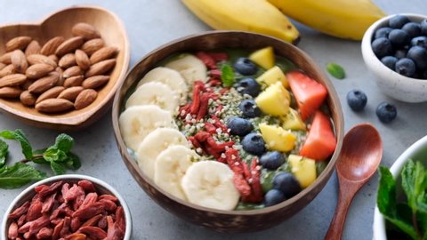 Healthy Raw Green Smoothie Bowl With Superfood Toppings Goji Berry, Banana, Mango, Hemp Seeds And Blueberry