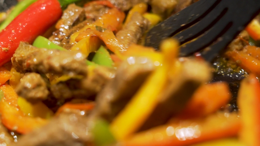 Cooking Delicious Mexican Fajitas Meat and Vegetables. Close-up of Colorful Vegetables and Meat Being Fried and Stewed. Royalty-Free Stock Footage #1047400675