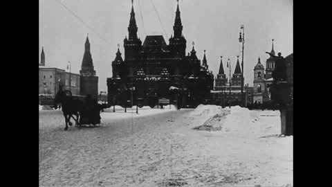 CIRCA 1914 - Russians walk and ride in horse-drawn sleds down the wintry streets of Moscow, trying to stay warm.