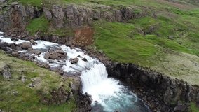 Epic video of a Kayaker paddling off of a waterfall in Iceland. Filmed with a drone in 4K. Beautiful rocks, grass, and clear water.