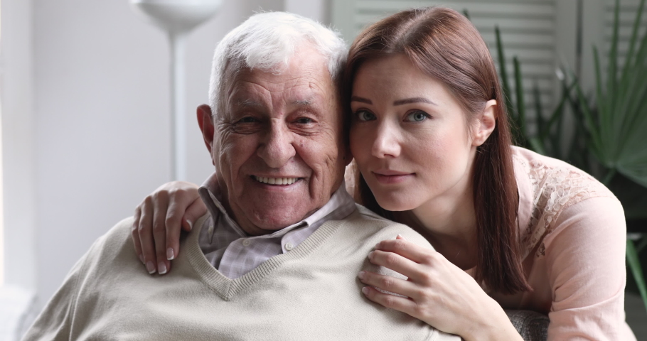 Loving smiling young adult granddaughter hug old elder grandfather at retirement home. happy grown grandchild cheerful face embrace senior grandpa bonding, close up 2 two age generation family Royalty-Free Stock Footage #1047422599