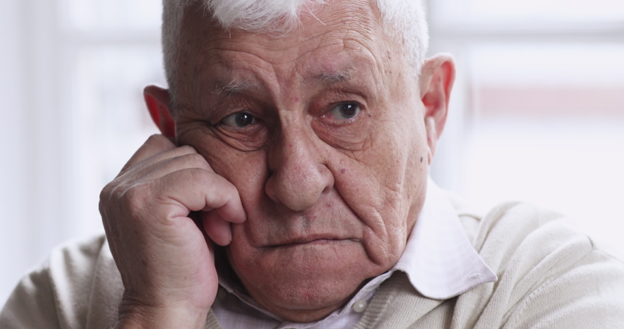Worried thoughtful senior old adult 80s man sit alone at home thinking of lonely life. upset elderly gray-haired grandpa look away feel sorrow anxiety concept, close up old grandparent sad face view. Royalty-Free Stock Footage #1047425104