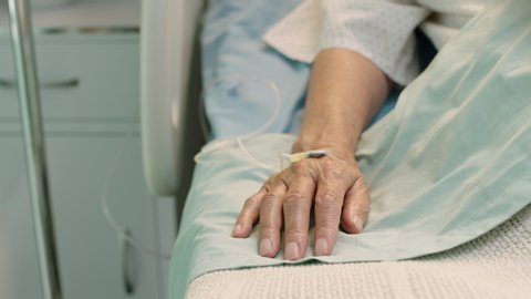 old woman in hospital bed moving finger waking up from coma elderly patient with intravenous drip in hand receiving medical treatment modern healthcare