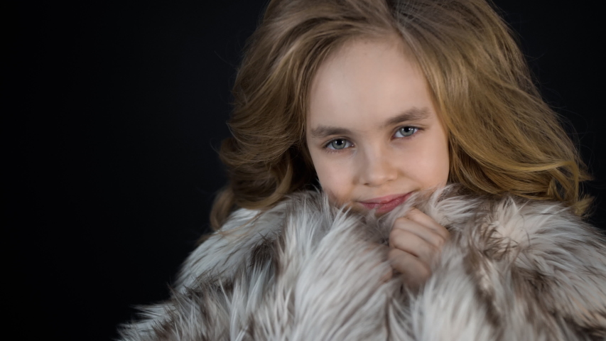 Smiling Face Portrait of Little Girl Looks Camera. Beautiful Fashionable Child Model with Hair Style in Modern Clothes Poses on Black Background. Emotion of Cute Stylish Small Lady, Pretty Glamour Kid