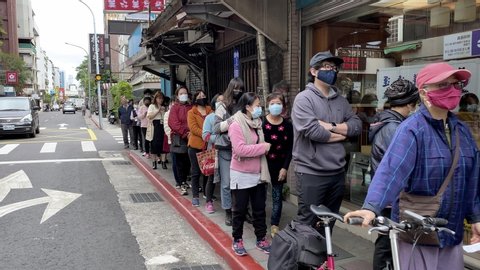 Taipei, Taiwan-06 February, 2020: 4K, People in line up at pharmacy to buy surgical mask to reduce risk of corona virus infection. Protective masks are very limited. COVID-19 epidemic of China.-Dan