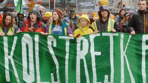 BRISTOL, c. 2020 - Greta Thunberg, wearing a yellow overcoat, leads a School Strike for Climate march in Bristol, England, UK with over 20,000 students